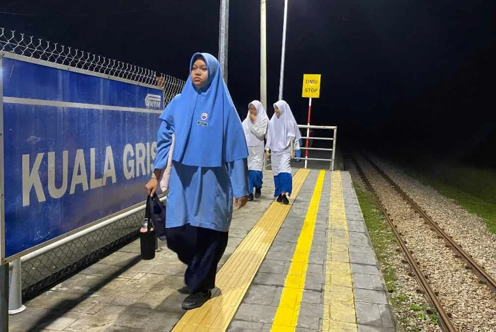 Pelajar SMK Dabong, Kuala Krai menunggu ketibaan kereta api di Kuala Gris. Foto: HAZELEN LIANA KAMARUDIN