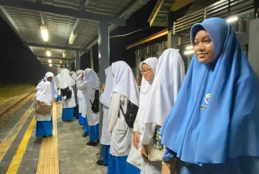 Para pelajar SMK Dabong, Kuala Krai menunggu ketibaan kereta api seawal jam 6 pagi di Stesen Kereta Api Kuala Gris pada Ahad. Foto HAZELEN LIANA KAMARUDIN