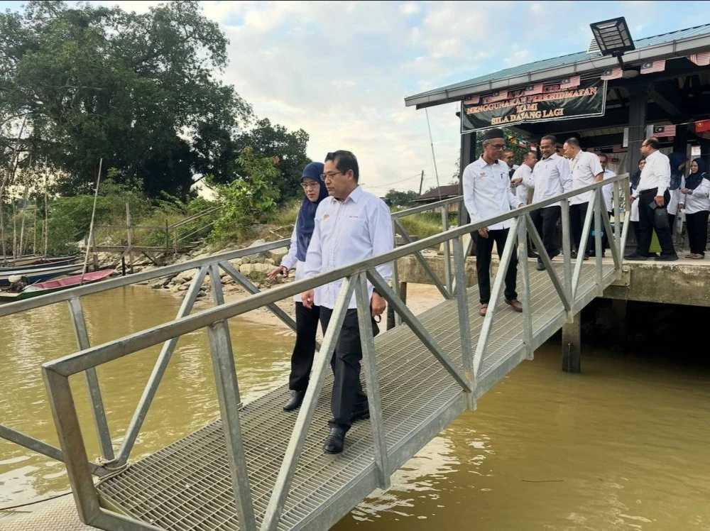 Wan Hashim (kanan) diiringi Siti Norina (kiri) tiba di Jeti Kok Majid untuk menaiki bot ke Pulau Beluru.
•Foto:SINAR HARIAN/ADILA SHARINNI WAHID