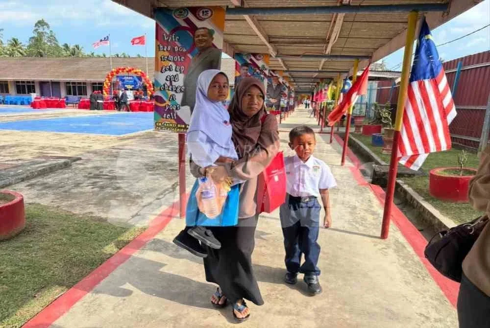 Siti Nur Najwa (kiri) didukung ibunya untuk ke kelas.