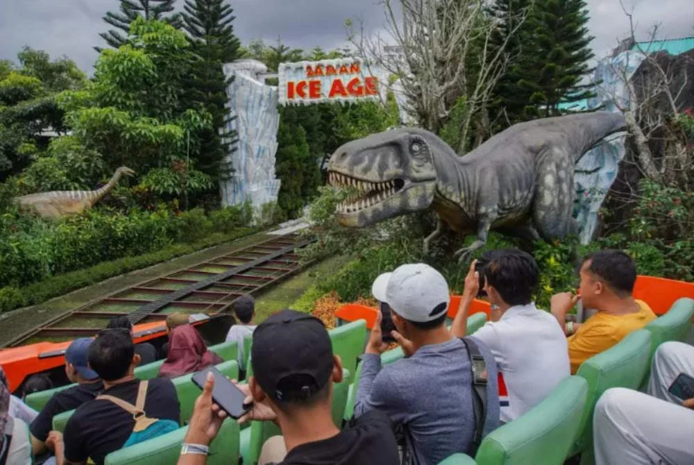 Pelancong menikmati pengalaman menaiki gerabak terbuka yang melalui landasan kereta api di Jawa Timur Park di Batu. Foto Agensi