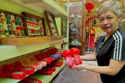 Angeli menunjukkan terompah yang dihasilkan dan dijual di premisnya.