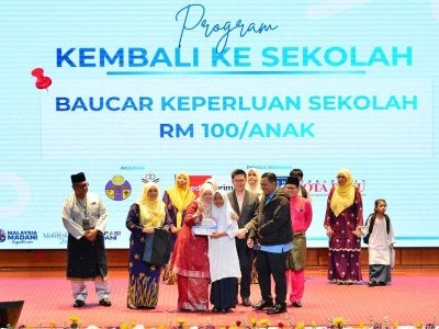 Menteri Pendidikan Fadhlina Sidek sempat merakam gambar kenangan bersama dengan salah seorang murid yang menerima bantuan Baucar Keperluan Sekolah pada majlis Amanat Tahun Baharu 2026 Kementerian Pendidikan Malaysia di Putrajaya pada Jumaat. / Foto: Asril Aswandi Shukor