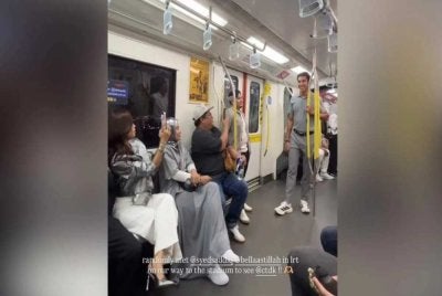 Syed Saddiq dan Bella menaiki LRT menuju ke Stadium Nasional Bukit Jalil. - Foto IG Natashaatika