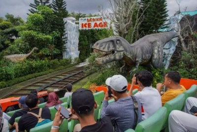 Pelancong menikmati pengalaman menaiki gerabak terbuka yang melalui landasan kereta api di Jawa Timur Park di Batu. Foto Agensi