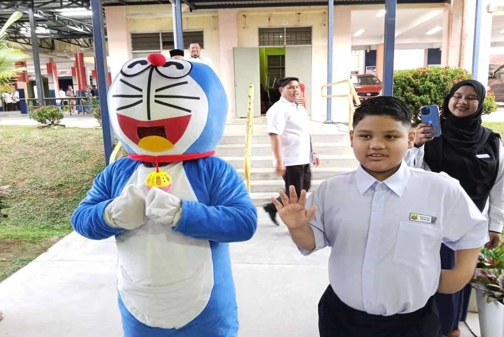 Kehadiran maskot menceriakan murid SK Dato' Onn Jaafar pada hari pertama persekolahan pada Isnin. 