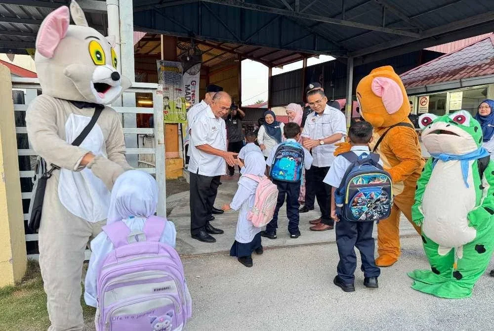 Mohammad Dziauddin (tiga dari kanan) menyambut murid-murid SK Tan Sri Awang Had Salleh di Balik Pulau pada Isnin.