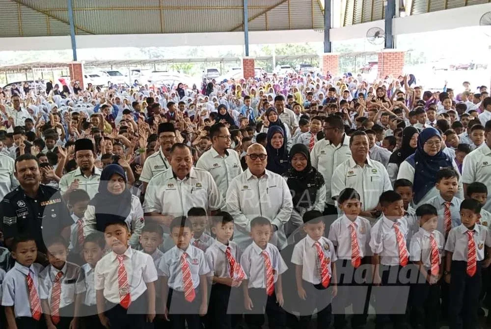 Aminuddin ( tengah) bergambar bersama murid SK Dato' Onn Jaafar Simpang Renggam Kluang pada hari pertama sesi persekolahan.