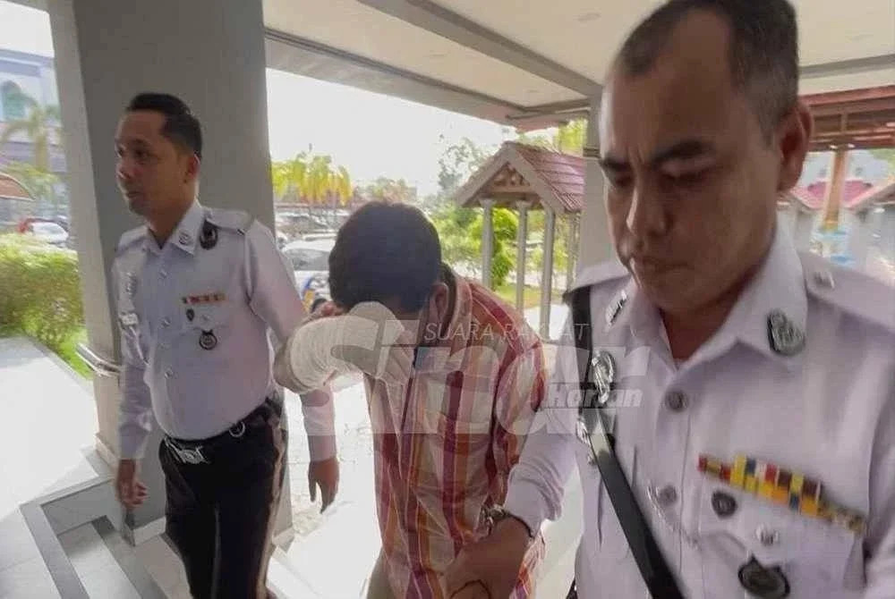 Tertuduh (tengah) ketika dihadapkan di Mahkamah Majistret Kuala Terengganu pada Isnin 