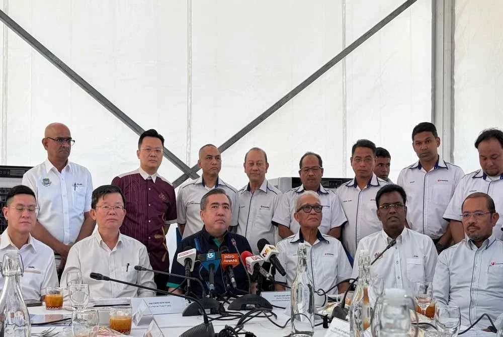 Anthony (duduk, tengah) mengadakan sidang akhbar selepas selepas meninjau operasi bas diesel Rapid Penang di Padang Kota pada Isnin.