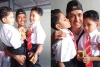 Mohd Azwan mendukung Akif (kanan) dan Afif (kiri) pada hari pertama sekolah di SK Dato' Onn Jaafar, Simpang Renggam, Kluang.