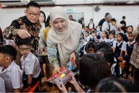 Fadhlina menyampaikan set alat tulis kepada murid pada Majlis Perasmian SJKC Ladang Regent Elmina hari ini - Foto: Bernama