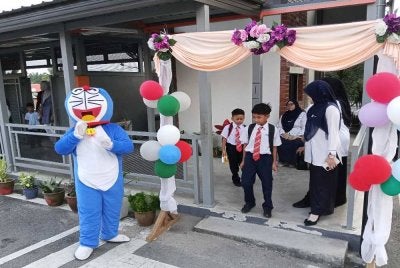 Maskot Doremon menyambut ketibaan murid pada hari pertama persekolahan di Sekolah SK Dato' Onn Jaafar Simpang Renggam, Kluang.