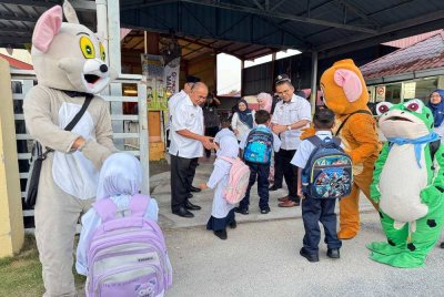 Mohammad Dziauddin (tiga dari kanan) menyambut murid-murid SK Tan Sri Awang Had Salleh di Balik Pulau pada Isnin.
