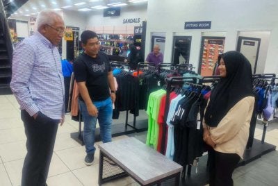 Pengerusi UMNO Kedah, Datuk Seri Mahdzir Khalid (kiri) hadir memberikan kata-kata semangat kepada Putri Qisyasemasa membeli kelengkapan persekolahn di Alor Setar.