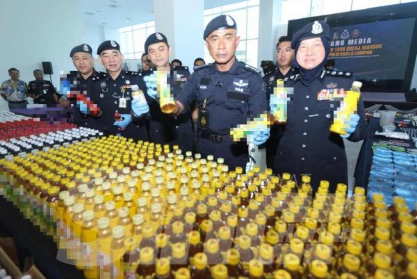 Fadil menunjukkan botol minuman yang dicampur dadah ketika sidang akhbar di IPK Kuala Lumpur pada Isnin.