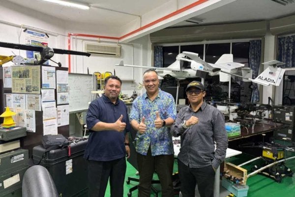 Rushdan (tengah) bersama-sama Hazry dan Irfan melihat model pembangunan Air Space Sandbox di Sungai Batu Pahat, Perlis.