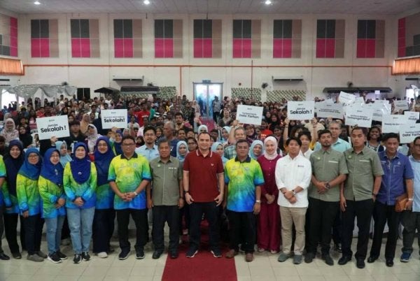 Ahmad Farhan bergambar bersama ibu bapa dan penerima pada Program Jom Kembali Ke Sekolah 2026 di di Dewan Atabara di sini, Sabtu lalu.