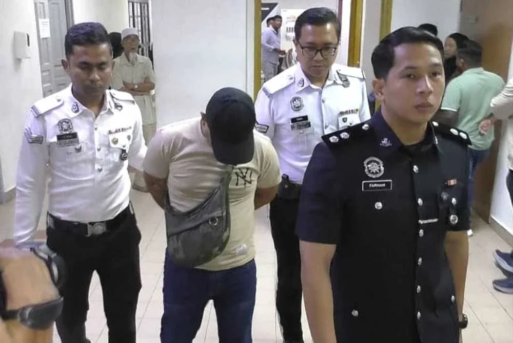 Tertuduh diiringi anggota polis ketika hadir di Mahkamah Majistret Johor Bahru pada Selasa.