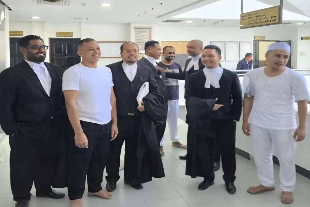 Muhammad Amiruddin (dua dari kiri), Vijandran Nair (empat dari kanan), dan Muhammad Faiz (kanan) bergambar bersama barisan peguam mereka, sejurus Mahkamah Tinggi Shah Alam pada Selasa melepas dan membebaskan mereka.