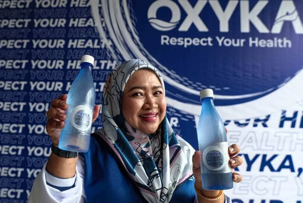 Anis menunjukkan minuman OXYKA bersaiz 500ml yang dijual di stesen minyak, pasar raya serta kedai-kedai runcit berhampiran. FOTO: Bernama 