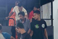 Mohamad Amirul Asyraf (kanan) turun dari kenderaan polis sebaik tiba di mahkamah.