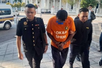 Suspek dibawa oleh pegawai SPRM ke Mahkamah Majistret George Town untuk perintah reman.