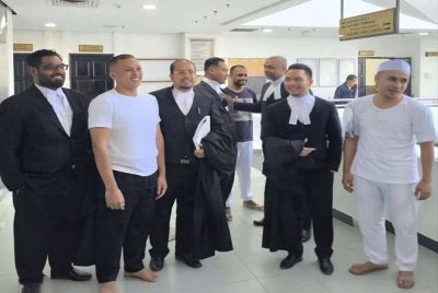 Muhammad Amiruddin (dua dari kiri), Vijandran Nair (empat dari kanan), dan Muhammad Faiz (kanan) bergambar bersama barisan peguam mereka, sejurus Mahkamah Tinggi Shah Alam pada Selasa melepas dan membebaskan mereka.