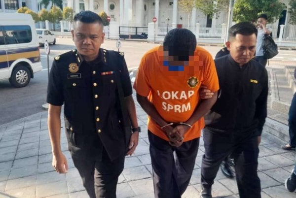 Suspek dibawa oleh pegawai SPRM ke Mahkamah Majistret George Town untuk perintah reman.
