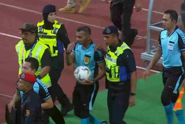 Logeswaran (tengah) diiringi keluar padang dengan kawalan ketat anggota keselamatan dan polis selepas tamat perlawanan.