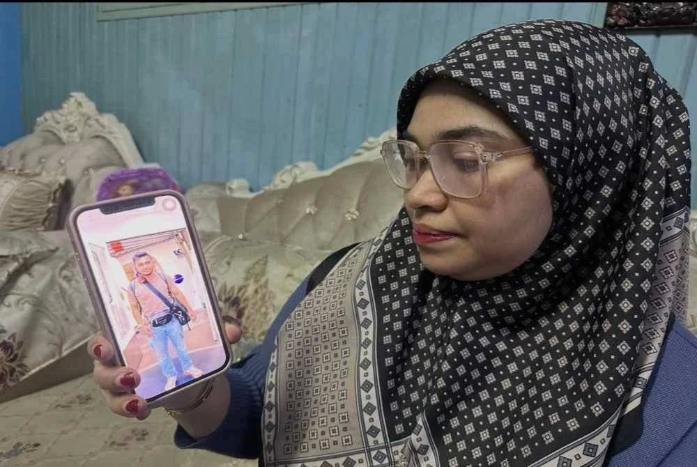 Siti Sarah menunjukkan gambar adiknya yang maut dalam kemalangan di Gua Musang.