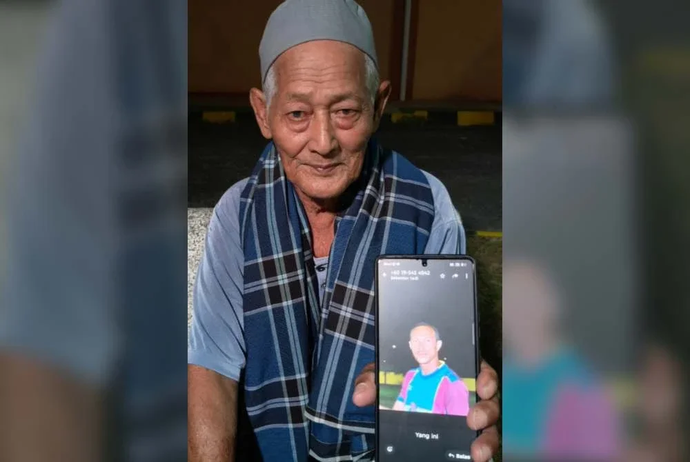 Mat Jusoh menunjukkan gambar arwah menantunya, Allahyarham Nik Azmi semasa berada di Unit Forensik Hospital Gua Musang.