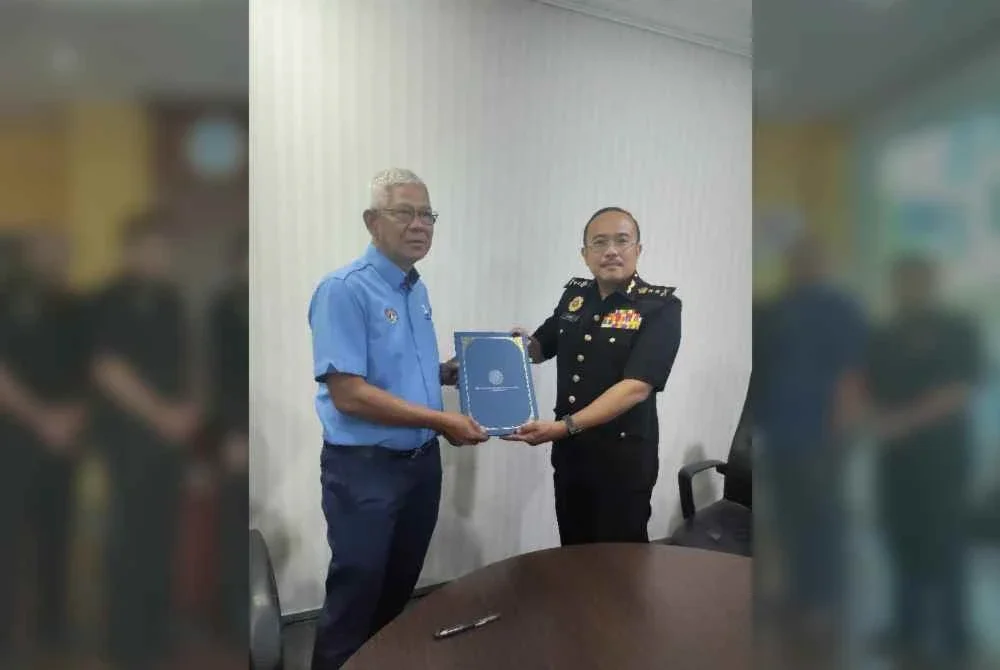 Pengarah SPRM Sabah, Datuk Mohd Fuad Bee Basrah (kiri) menerima dokumen yang telah ditandatangani oleh Ketua Pengarah LKIM, Hamdan Mamat di pejabat LKIM Sabah pada Selasa.