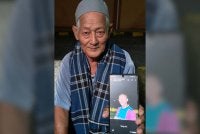 Mat Jusoh menunjukkan gambar arwah menantunya, Allahyarham Nik Azmi semasa berada di Unit Forensik Hospital Gua Musang.