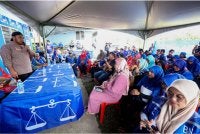 Calon BN Parlimen Kinabatangan pada Pilihan Raya Kecil (PRK) Parlimen Kinabatangan, Mohd Kurniawan Naim Moktar atau Naim Moktar (kiri) berucap di hadapan jentera pilihan raya ketika mengadakan lawatan ke Pusat Daerah Mengundi (PDM) Kampung Paris baru-baru ini. Foto Bernama