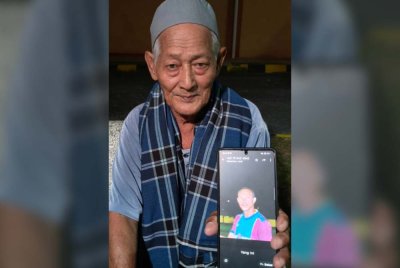 Mat Jusoh menunjukkan gambar arwah menantunya, Allahyarham Nik Azmi semasa berada di Unit Forensik Hospital Gua Musang.