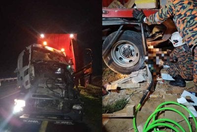 Anggota bomba cuba mengeluarkan mayat mangsa yang tersepit di bawah lori.