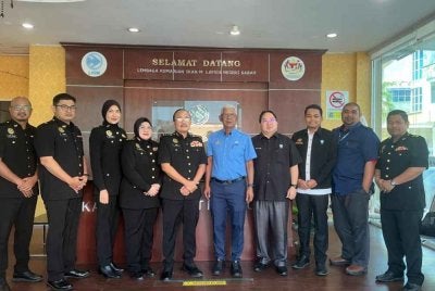 Pengarah SPRM Sabah, Datuk Mohd Fuad Bee Basrah (lima dari kiri) dan Ketua Pengarah LKIM, Hamdan Mamat (lima dari kanan) bergambar di hadapan pejabat LKIM Sabah di sini pada Selasa.