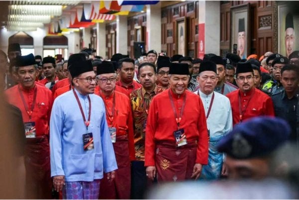 Anwar diiringi Presiden UMNO, Datuk Seri Dr Ahmad Zahid Hamidi (tengah) ketika tiba pada Perhimpunan Agung UMNO 2023 di Pusat Dagangan Dunia Kuala Lumpur (WTCKL). Foto fail Bernama