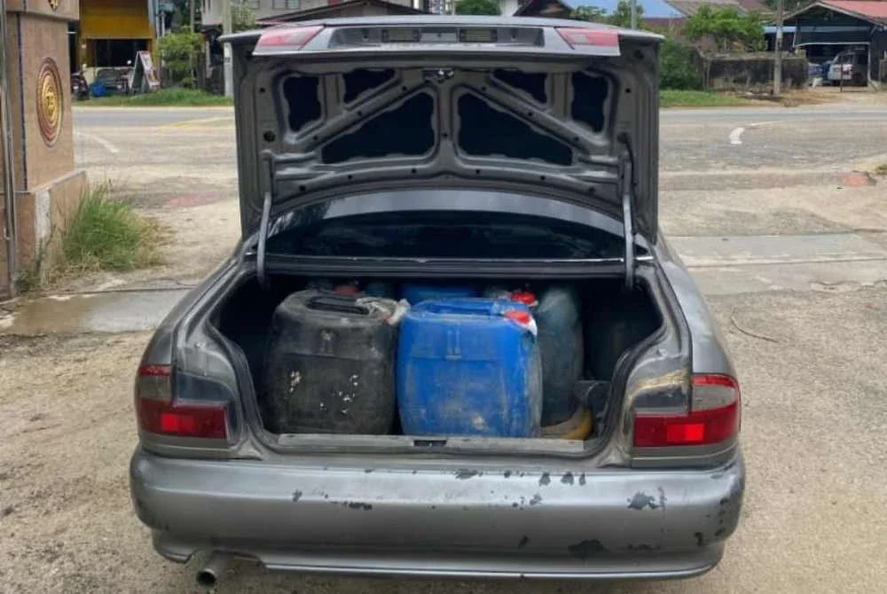 Hasil pemeriksaan menemui lima tong jerikin berisi minyak petrol di dalam but kereta, selain tangki minyak telah diubah suai. Foto KPDN