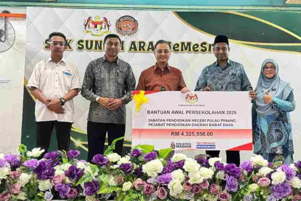 Mohamad (tengah) menyampaikan cek cura bernilai RM4.33 juta bagi BAP 2026 daerah Barat Daya di SMK Sungai Ara pada Khamis.
