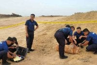 Anggota polis memeriksa bom aerial yang masih aktif. 