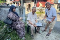 Syed Abdul Hamid (tengah) memegang al-Quran bersama air zamzam yang selamat dalam kebakaran rumahnya. - Foto Sinar Harian/Adila Sharinni Wahid
