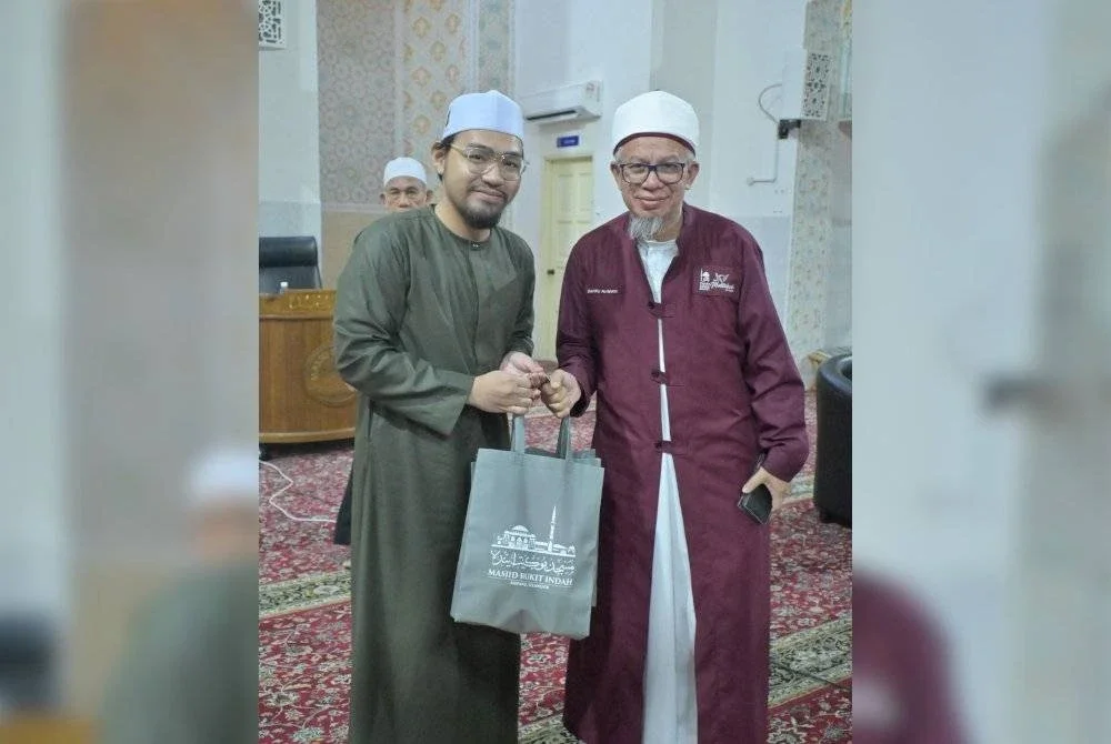 DR ZULKIFLI (kanan) menerima cenderamata daripada Pengurus Masjid Bukit Indah, Ustaz Muhammad Mizan Mohd Khaidir. 