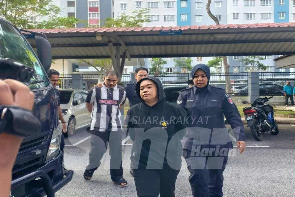 Dayang Norshida dan Masran dibawa polis ketika tiba di mahkamah