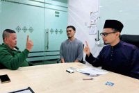 Adi (kiri) melafazkan dua kalimah syahadah yang dipimpin Mohd Muzil Adli baru-baru ini. Foto FB MUIP