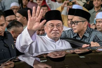 Anwar melambaikan tangan ke arah jemaah selepas menunaikan solat Jumaat di Masjid Usamah Bin Zaid pada Jumaat. Foto: Bernama 