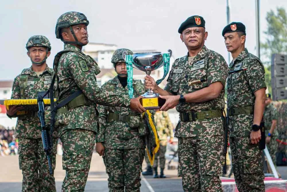 Azhan (dua dari kanan) menyampaikan Anugerah Perajurit Muda Lelaki Siri 204 Keseluruhan Terbaik Nor Amirul Afiq Nor Arifin (dua dari kiri) pada Perbarisan Tamat Latihan Perajurit Muda Lelaki Siri 204/25 dan Wanita Siri 50/25 di Padang Kawad Pusat Latihan Asas Tentera Darat (PUSASDA), Port Dickson hari ini. Foto Bernama