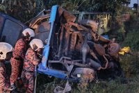 Anggota bomba cuba mengeluarkan mangsa yang tersepit dalam van kilang berkenaan. - foto BBP Bandar Baru Kulai