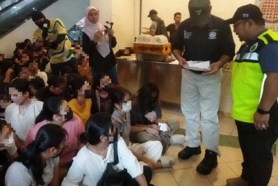 Lokman (dua kanan) sedang memeriksa dokumen warga asing di sebuah pusat beli belah di Ampang di sini pada Sabtu.
